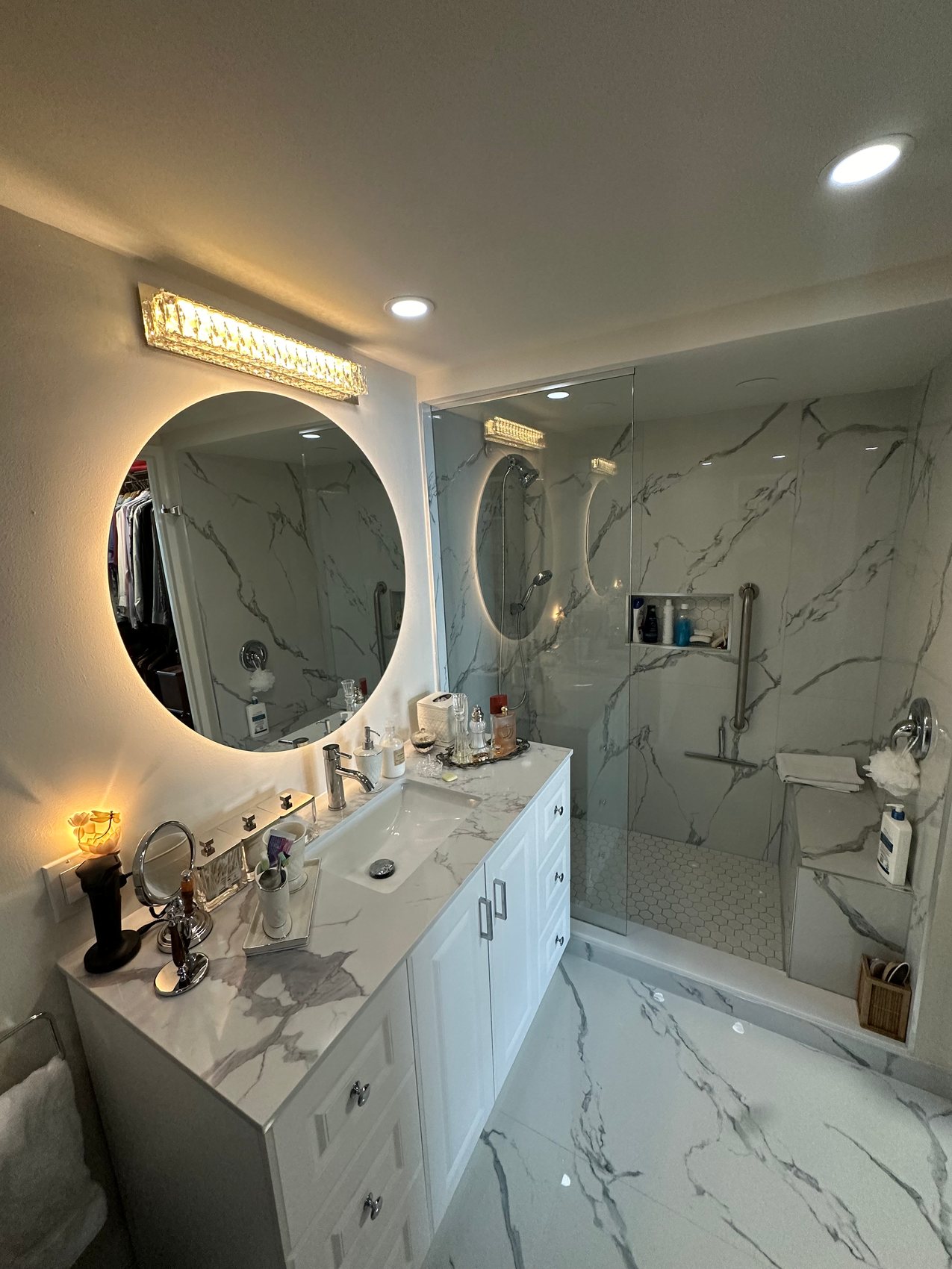 Marble ensuite with a backlit round mirror
